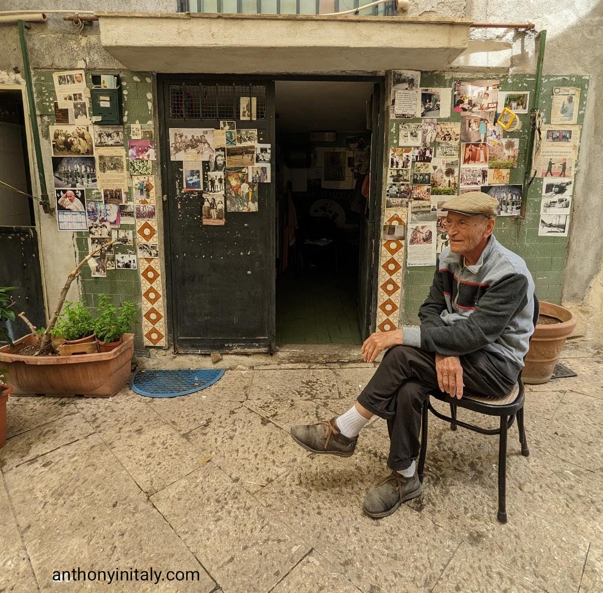 picture of old sicilian man sitting in front of his house