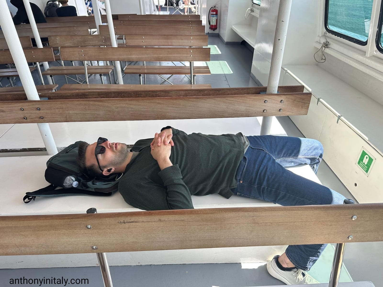 guy sleeping on a seat on a ferry