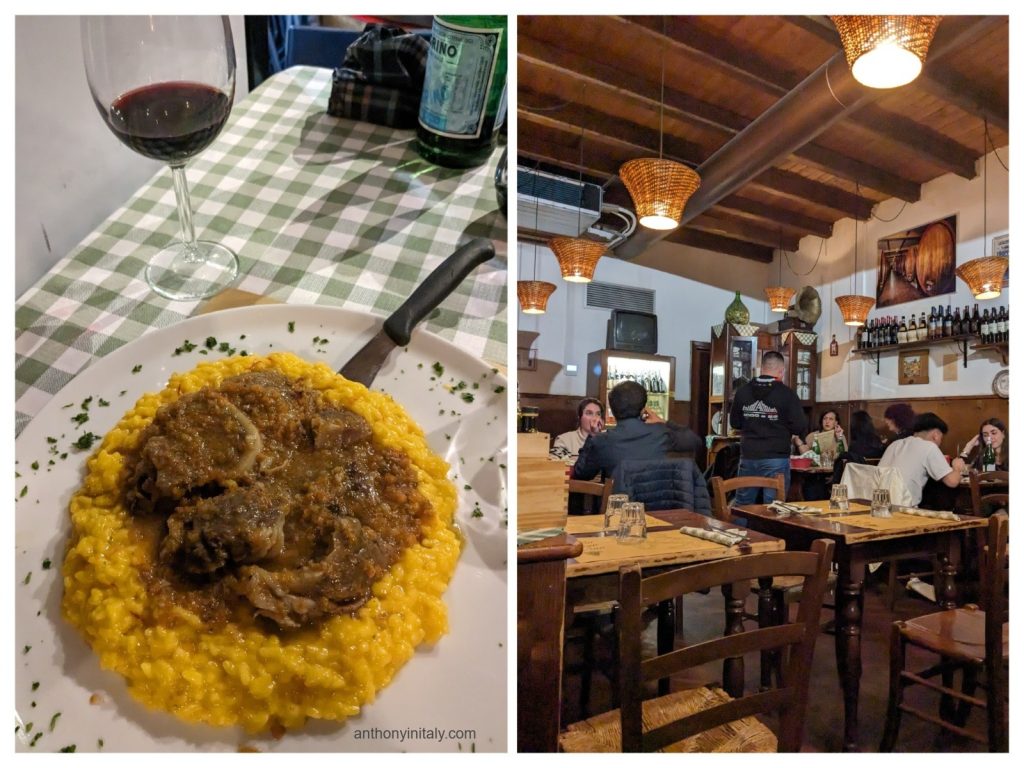 A plate of ossobuco served over bright yellow saffron risotto with a glass of red wine, inside a cozy trattoria with wooden beams and warm lighting.