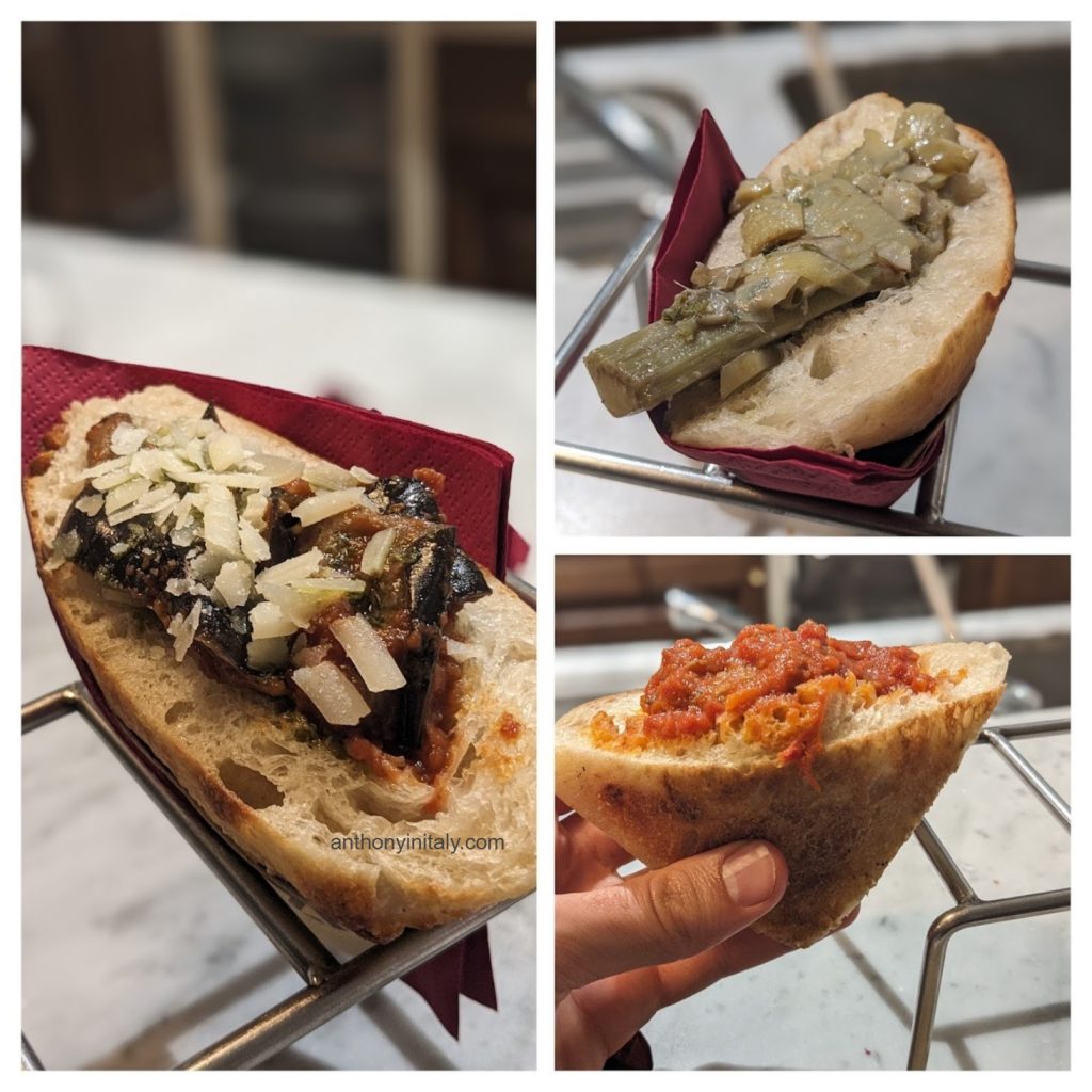 Three trapizzino varieties at Trapizzino Milano — eggplant with pecorino, artichokes, and polpette al sugo in a triangular pocket of pizza bianca