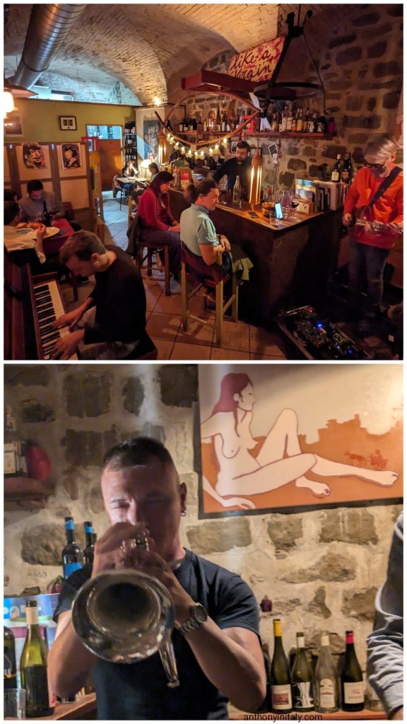 Live jazz with piano, electric guitar, and trumpet inside the brick-vaulted, stone-walled dining room of La Fame vineria in Perugia