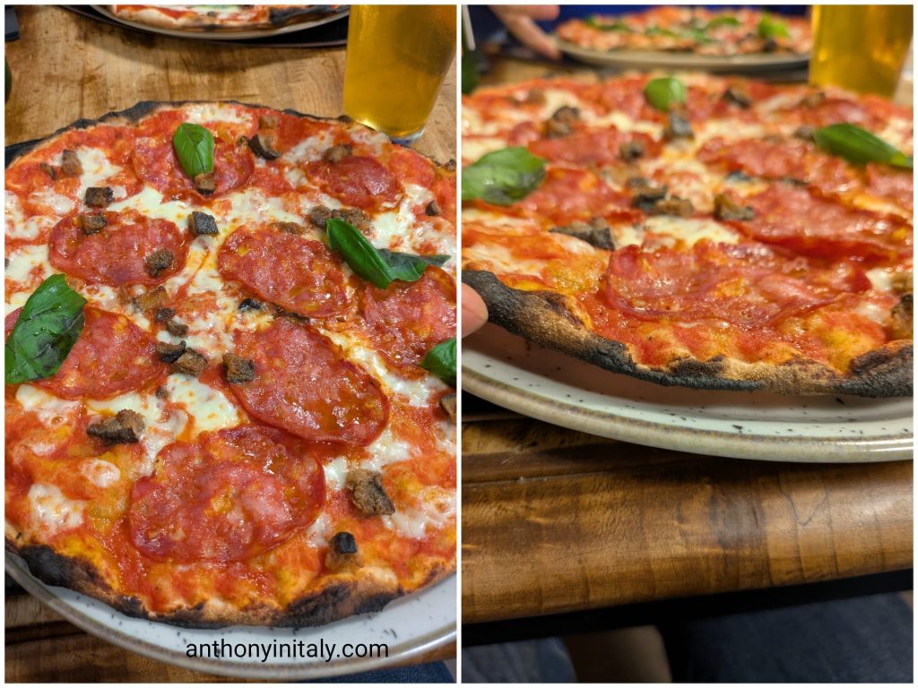 Thin, crispy Roman-style pizza with tomato, mozzarella, spicy salami, eggplant, and basil at Margherita Lab in Elce, Perugia, with a side view showing how thin the crust is