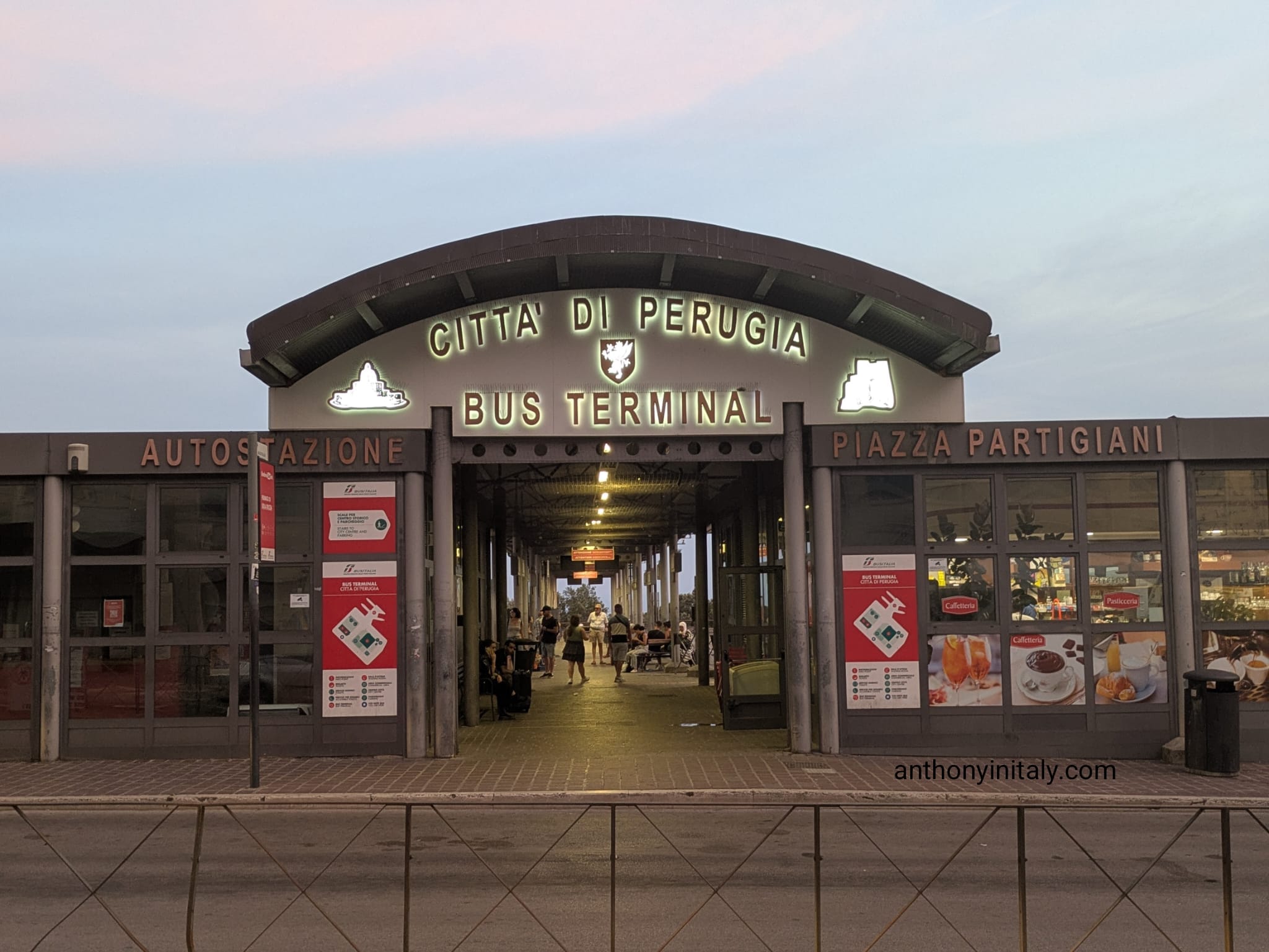 Entrance to the Città di Perugia bus terminal at Piazza Partigiani, lit up at dusk